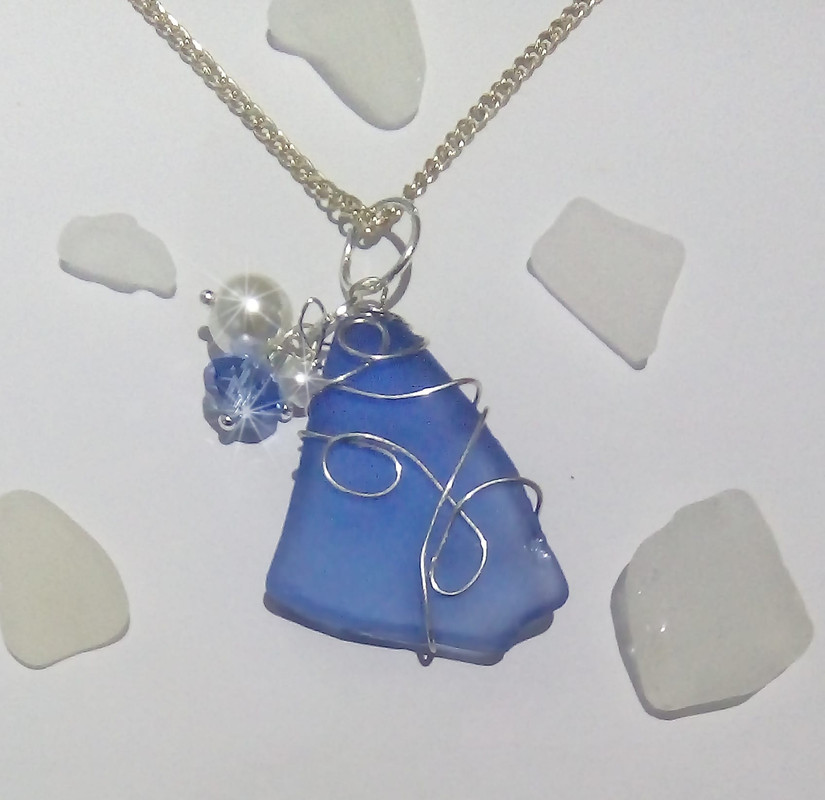 This sea glass has 3 bead charms hanging off the bail